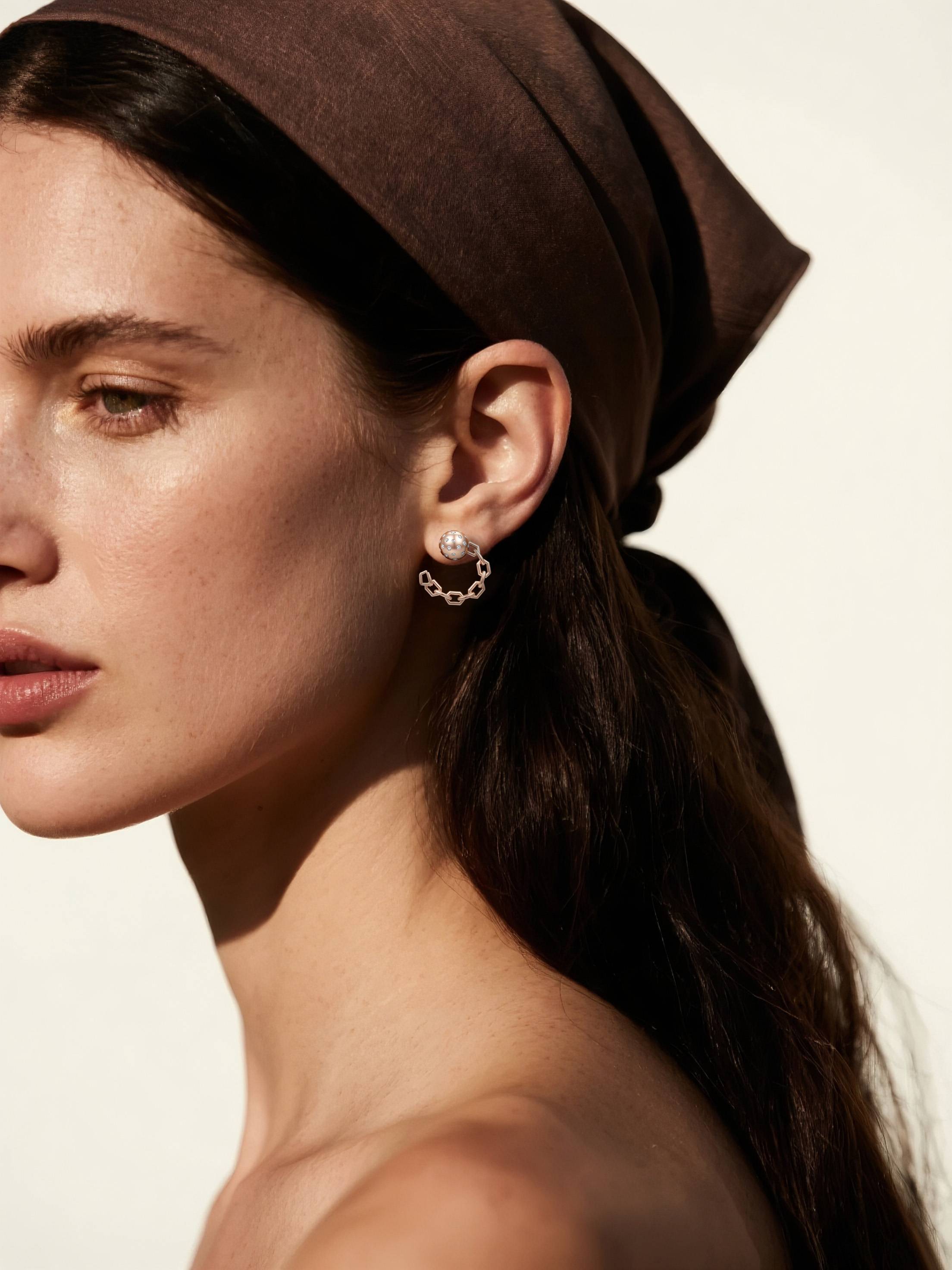 Customer wearing BuzzBloom rose gold chain hoop earrings with crystal sphere studs, outdoor sunlight scene, modern women’s jewelry style