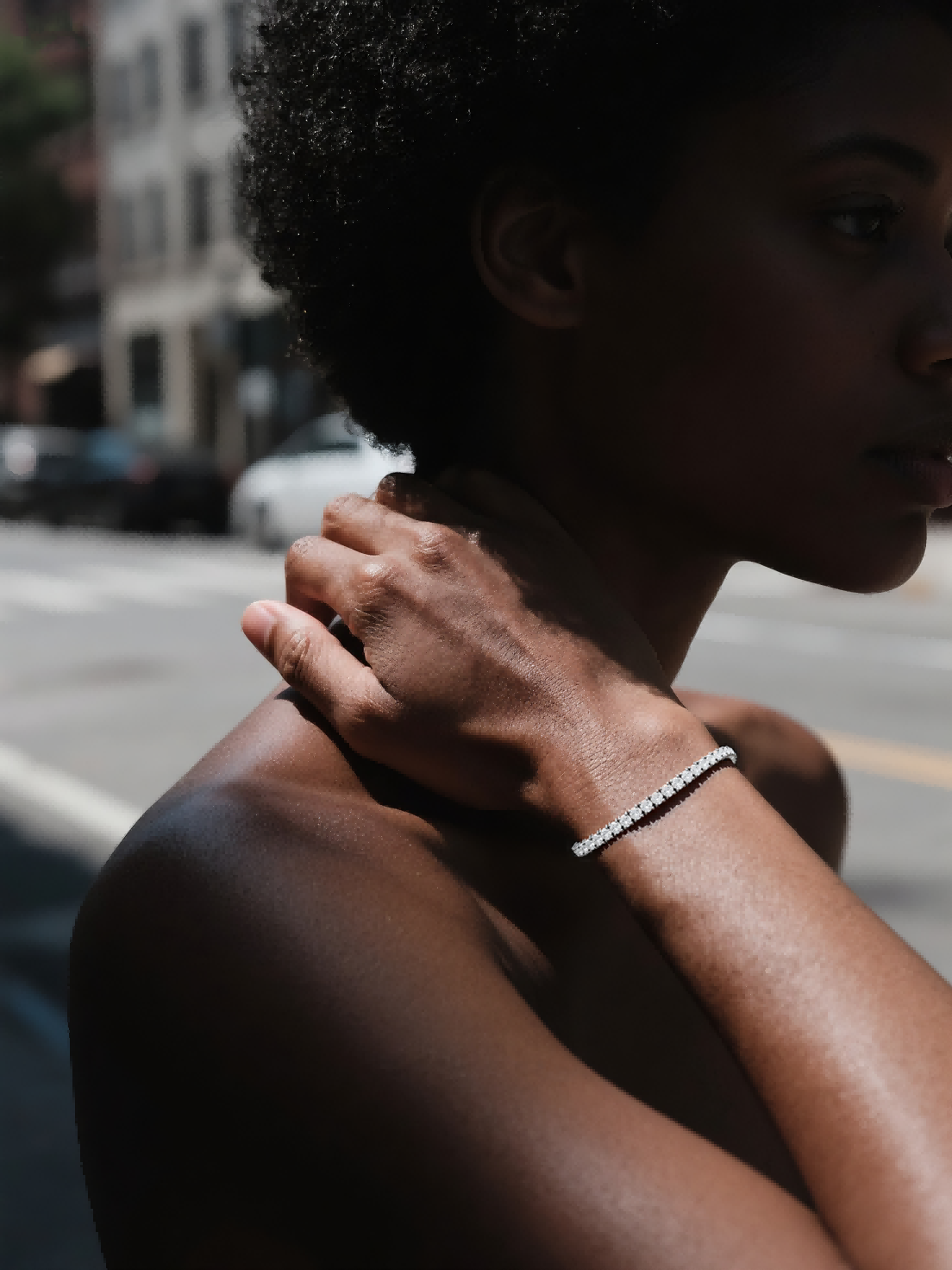 Customer wearing buzzbloom diamond gold tennis bracelet walking in city, fashionable woman