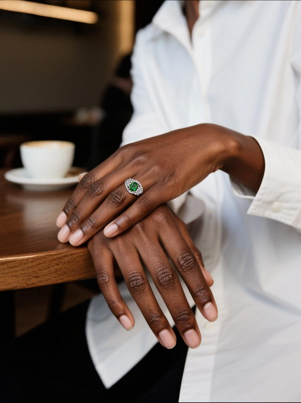Customer wearing BuzzBloom luxury emerald diamond cocktail ring in chic café scene, women’s statement jewelry