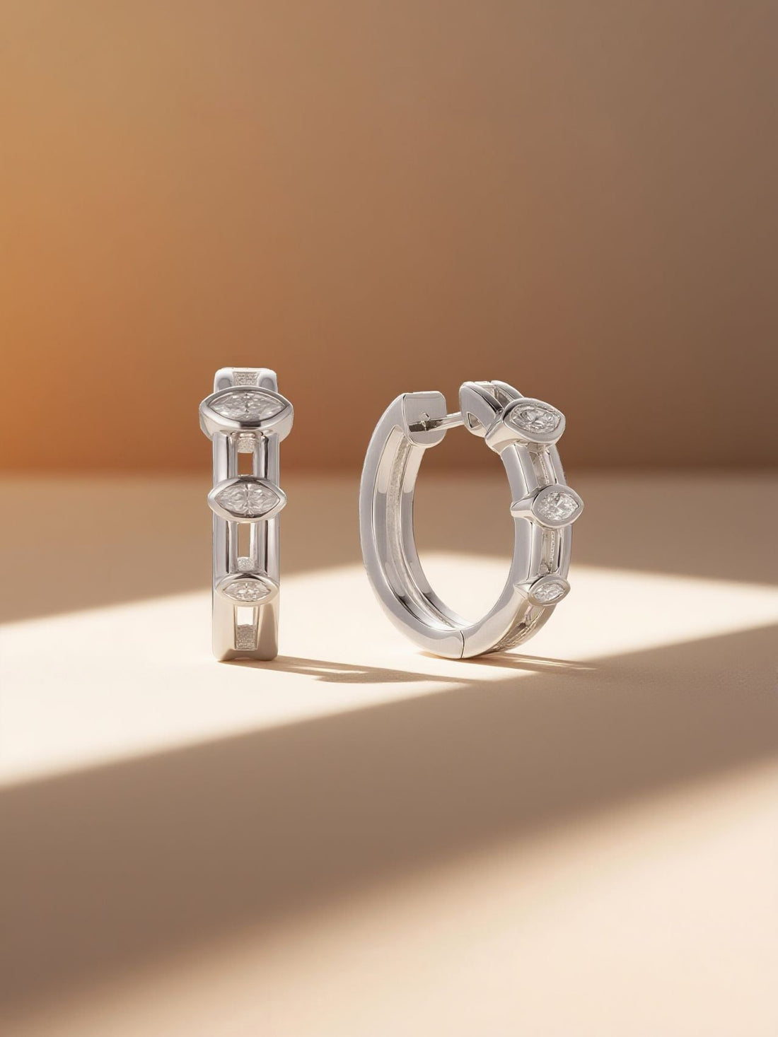 Own Your Bloom 14K white gold marquise diamond hoop earrings, lifestyle still life with warm sunbeam, Los Angeles.