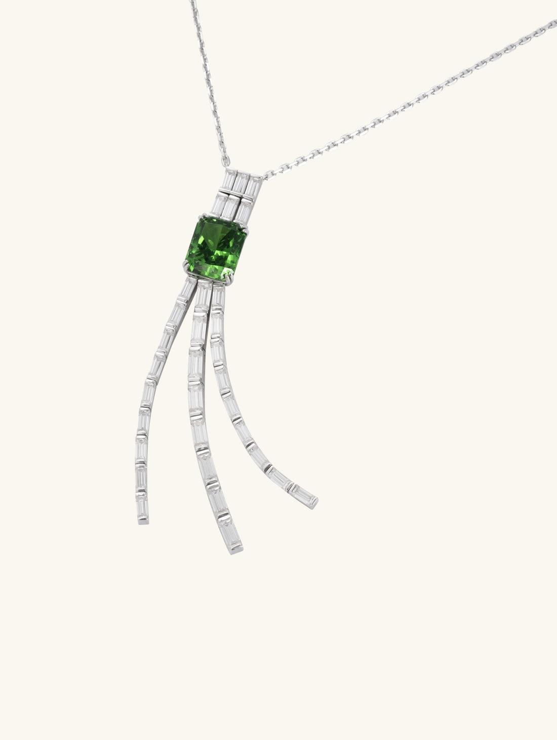 Own Your Bloom green gemstone tassel necklace front view in white gold, showcasing emerald-cut green gemstone with diamond tassel design, New York.
