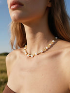 Customer wearing Australian White Shell Pearl necklace with 14K gold and diamond accents outdoors, elegant women’s fine jewelry