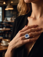 BuzzBloom customer wearing blue sapphire diamond halo ring in vintage style at café, elegant women’s statement jewelry
