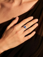 BuzzBloom customer showing BuzzBloom emerald sapphire baguette ring at luxury evening event for women