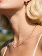 Customer wearing delicate rose gold layering necklace on yacht, elegant woman in summer dress