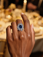 BuzzBloom customer showcasing blue sapphire floral cocktail ring at luxury dinner party – modern women’s statement accessory