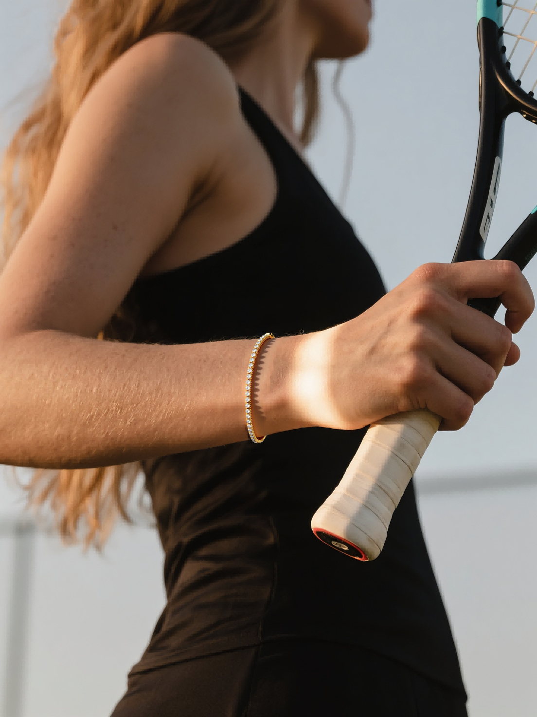 Customer wearing 14K gold diamond tennis bracelet on court – active lifestyle jewelry for women