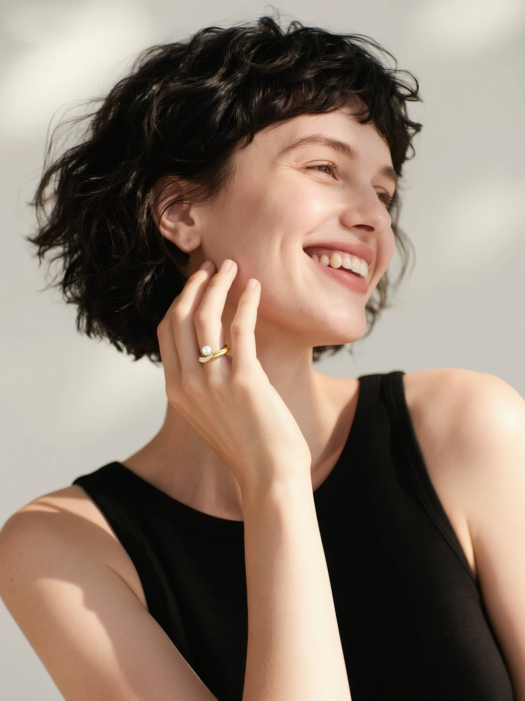 Customer wearing BuzzBloom luxury pearl engagement ring in 14k gold with diamonds, smiling in outdoor bridal lifestyle setting