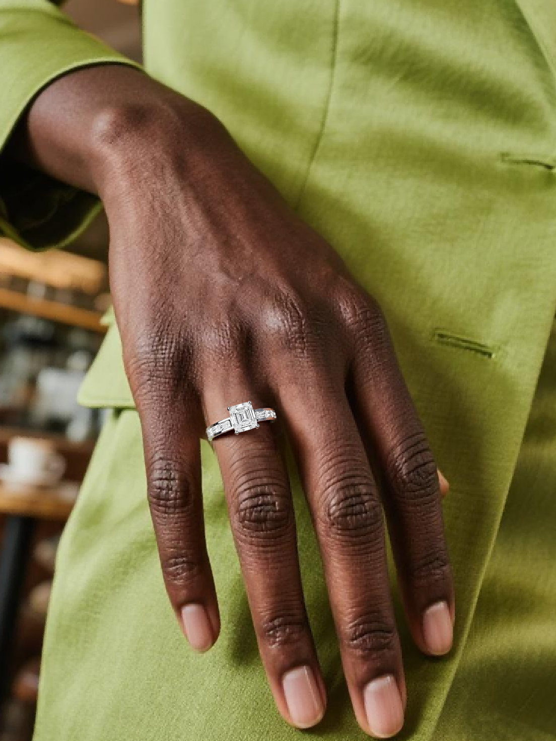 Customer wearing BuzzBloom emerald cut engagement ring in close-up hand view, elegant jewelry for women