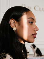 Customer wearing BuzzBloom square flower head diamond stud earrings, elegant indoor scene, women’s luxury earrings