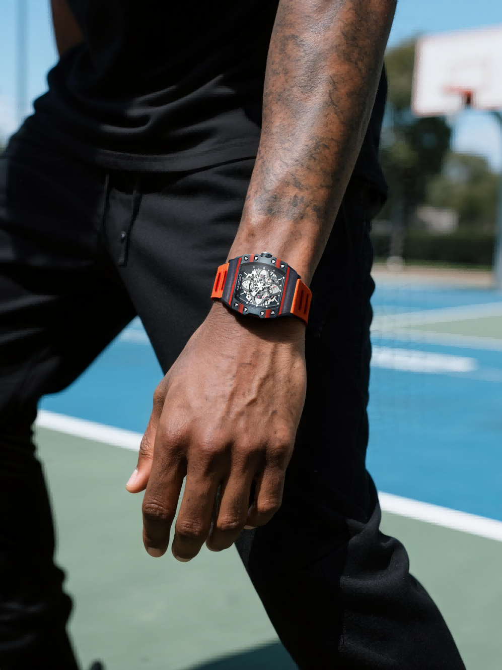 Customer wearing BuzzBloom stainless steel skeleton dial men’s watch with orange strap, outdoor streetwear look for men