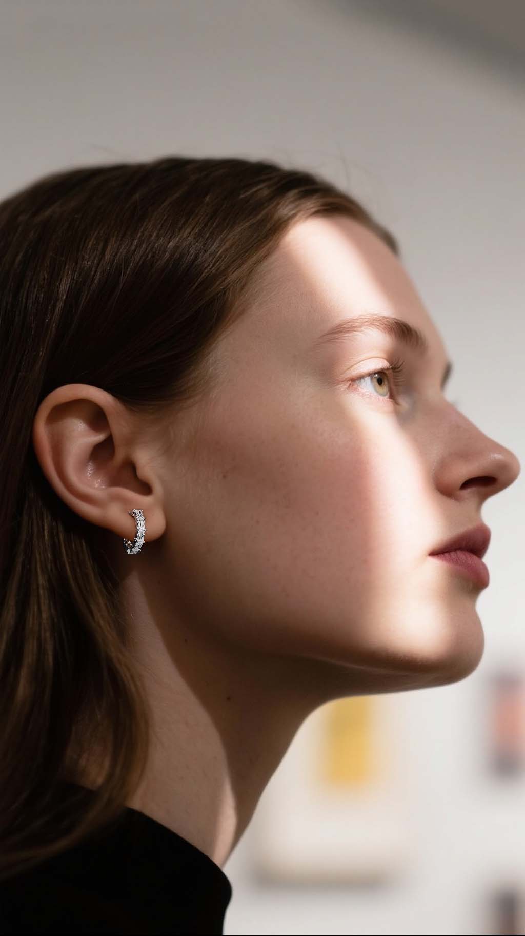 Customer wearing BuzzBloom moissanite hoop earrings in art gallery scene, stylish women jewelry audience