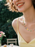 Customer wearing BuzzBloom multicolor gemstone necklace in garden scene, women’s elegant jewelry style