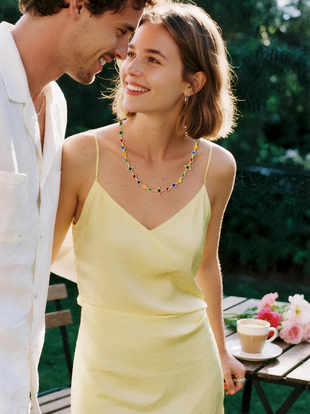 Customer wearing BuzzBloom colorful luxury necklace, romantic embrace outdoor, young couple jewelry moment