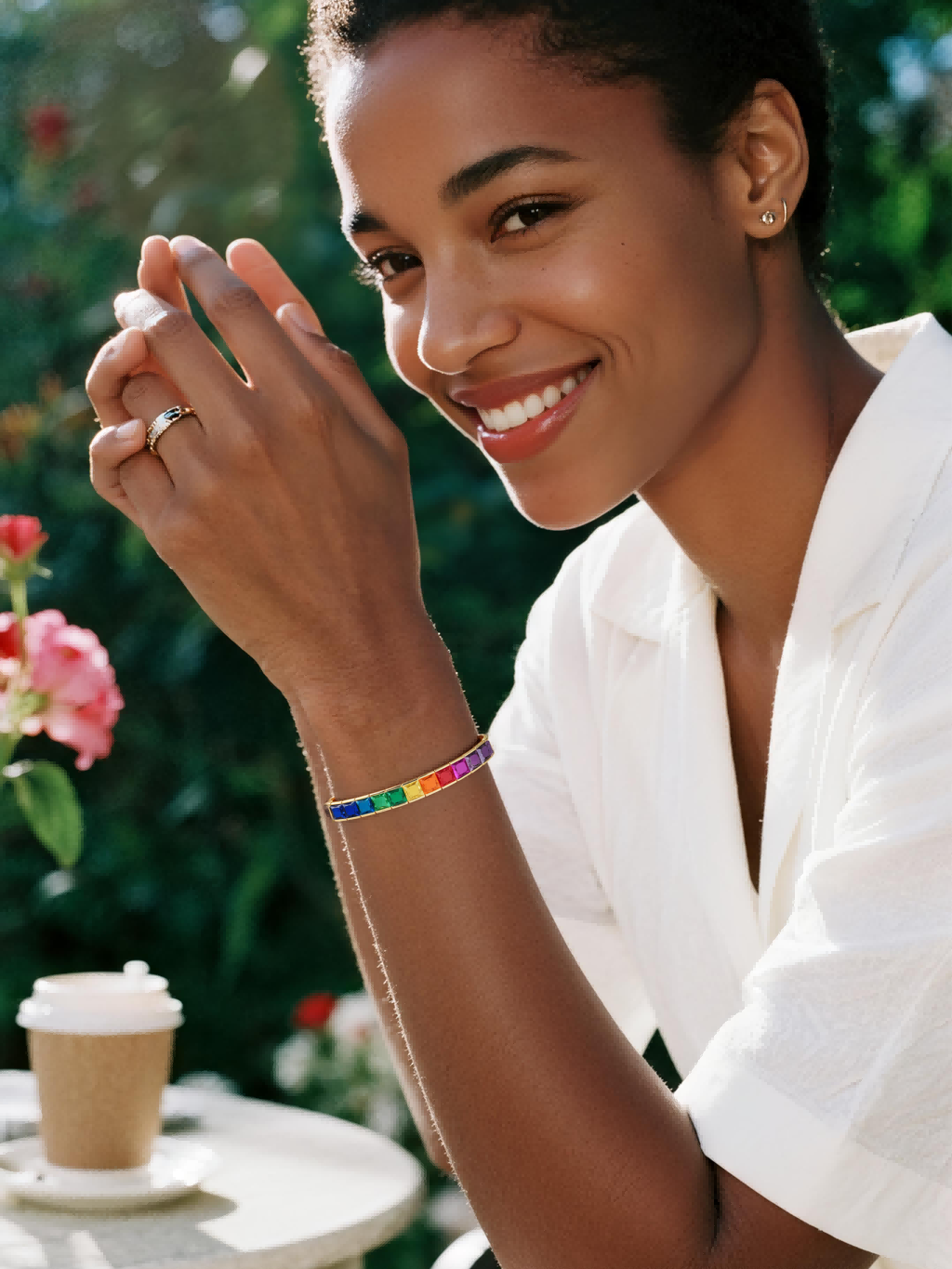 Customer wearing BuzzBloom luxury rainbow gemstone bracelet at social garden gathering, unisex fine jewelry