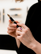 Customer wearing rose gold marquise pink gemstone cluster ring while holding a pen, luxury rose gold ring for women
