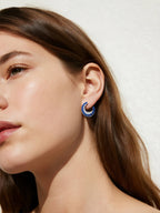Customer wearing sapphire hoop earrings in outdoor sunlight, stylish women’s statement jewelry
