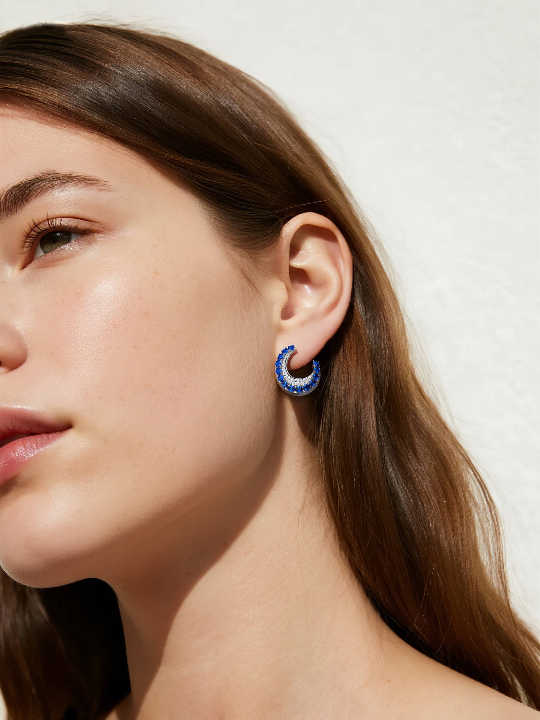 Customer wearing sapphire hoop earrings in outdoor sunlight, stylish women’s statement jewelry