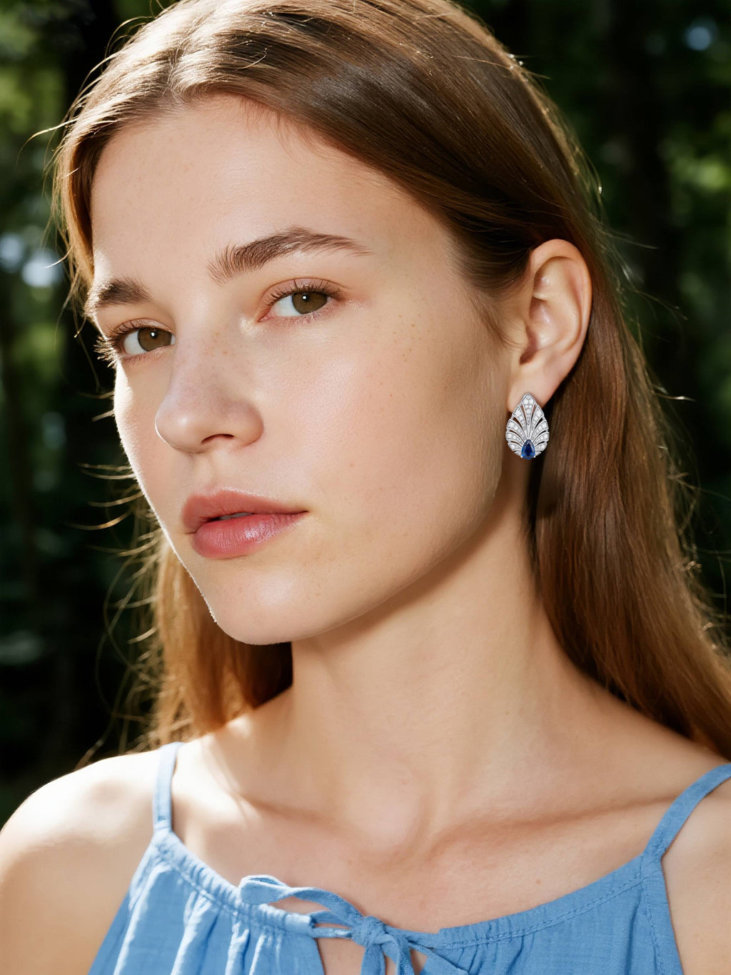 BuzzBloom customer wearing diamond sapphire earrings in close-up portrait, luxury gemstone jewelry for women