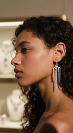 Customer wearing silver tassel earrings in jewelry boutique setting, stylish young woman