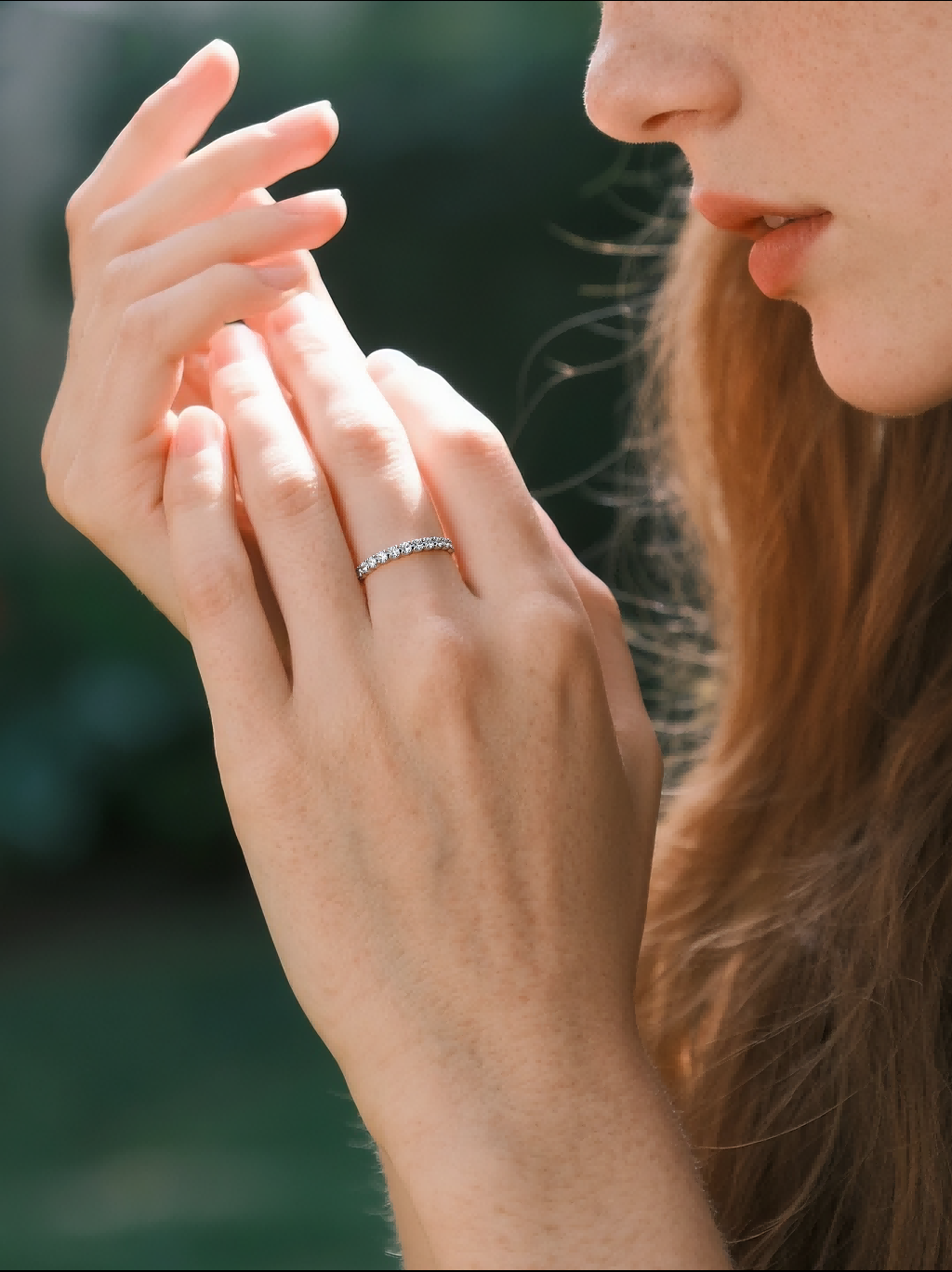 Customer wearing BuzzBloom stacked gold diamond ring in outdoor garden, stylish women accessory