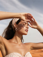 Customer wearing BuzzBloom statement rose gold chain hoop earrings, outdoor desert sunlight scene, stylish female jewelry look