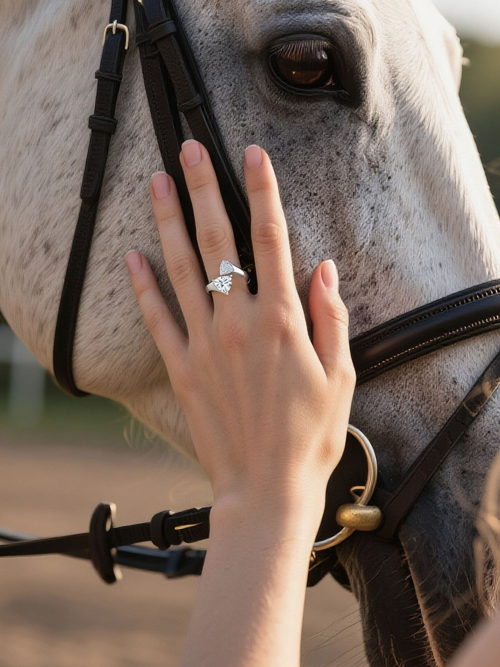 Customer wearing BuzzBloom trillion cut diamond bypass ring while horse riding, luxury women’s jewelry