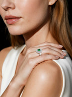 Customer wearing BuzzBloom vintage-inspired emerald halo ring in elegant event scene – women’s statement jewelry