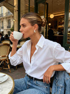 Model wearing 14K gold diamond hoop earrings in Brooklyn cafe - Bloomira NYC casual style