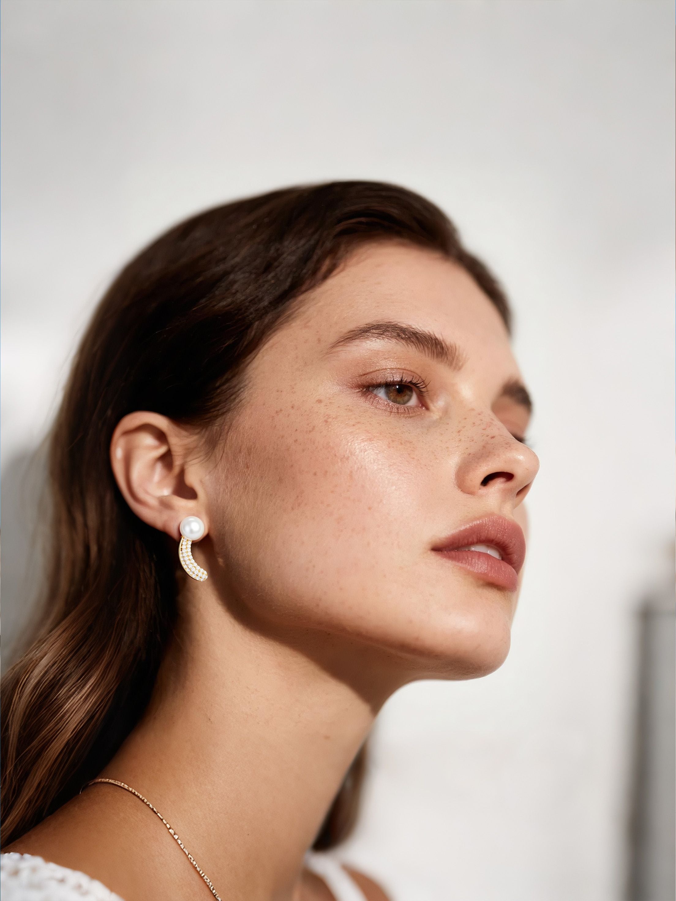 Woman wearing Own Your Bloom Australian white shell pearl 14K diamond stud earrings, portrait close-up, Houston USA.