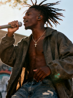 Close-up of a man wearing the Own Your Bloom 14K diamond cross pendant with palm tree background, Phoenix.