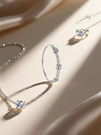 Own Your Bloom 14K diamond tennis bracelet on soft satin fabric surrounded by gold rings and necklaces, Dallas.