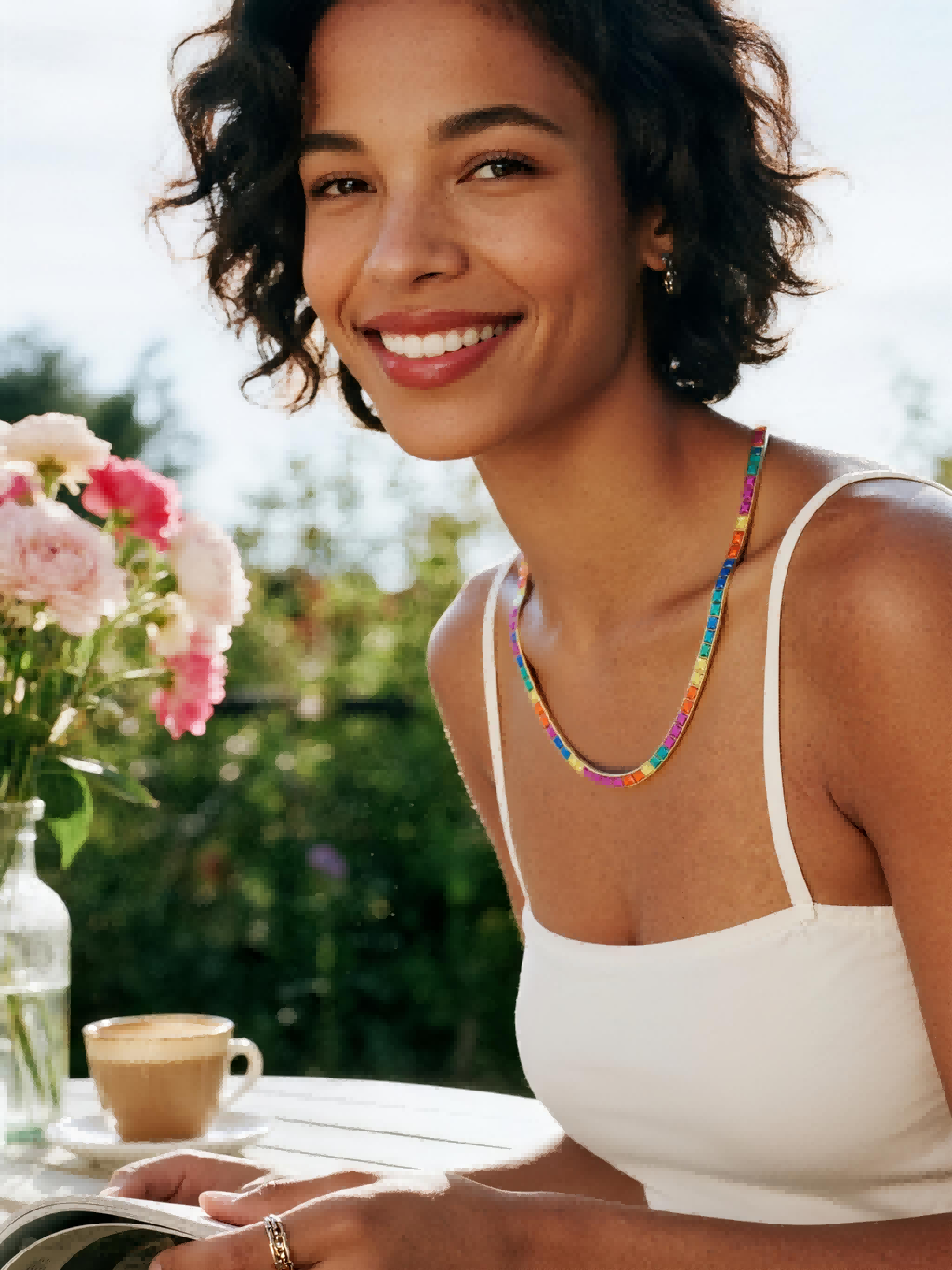 Own Your Bloom 14K rainbow diamond necklace worn by woman, outdoor smiling close-up, San Francisco.