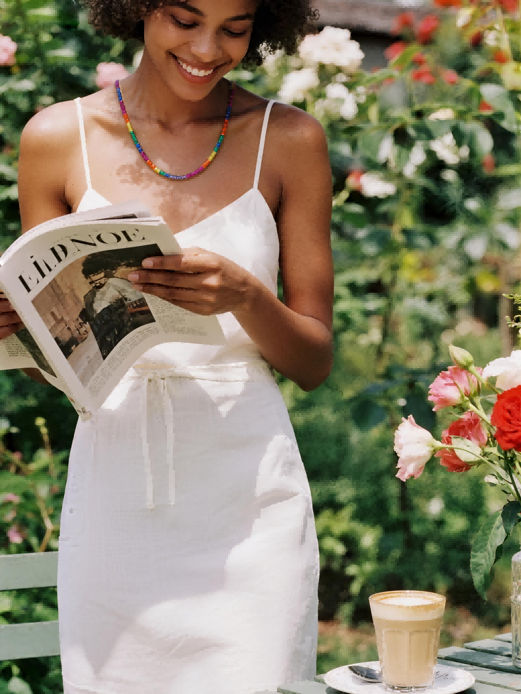 Own Your Bloom rainbow diamond necklace on woman model reading in garden, lifestyle portrait, Seattle.