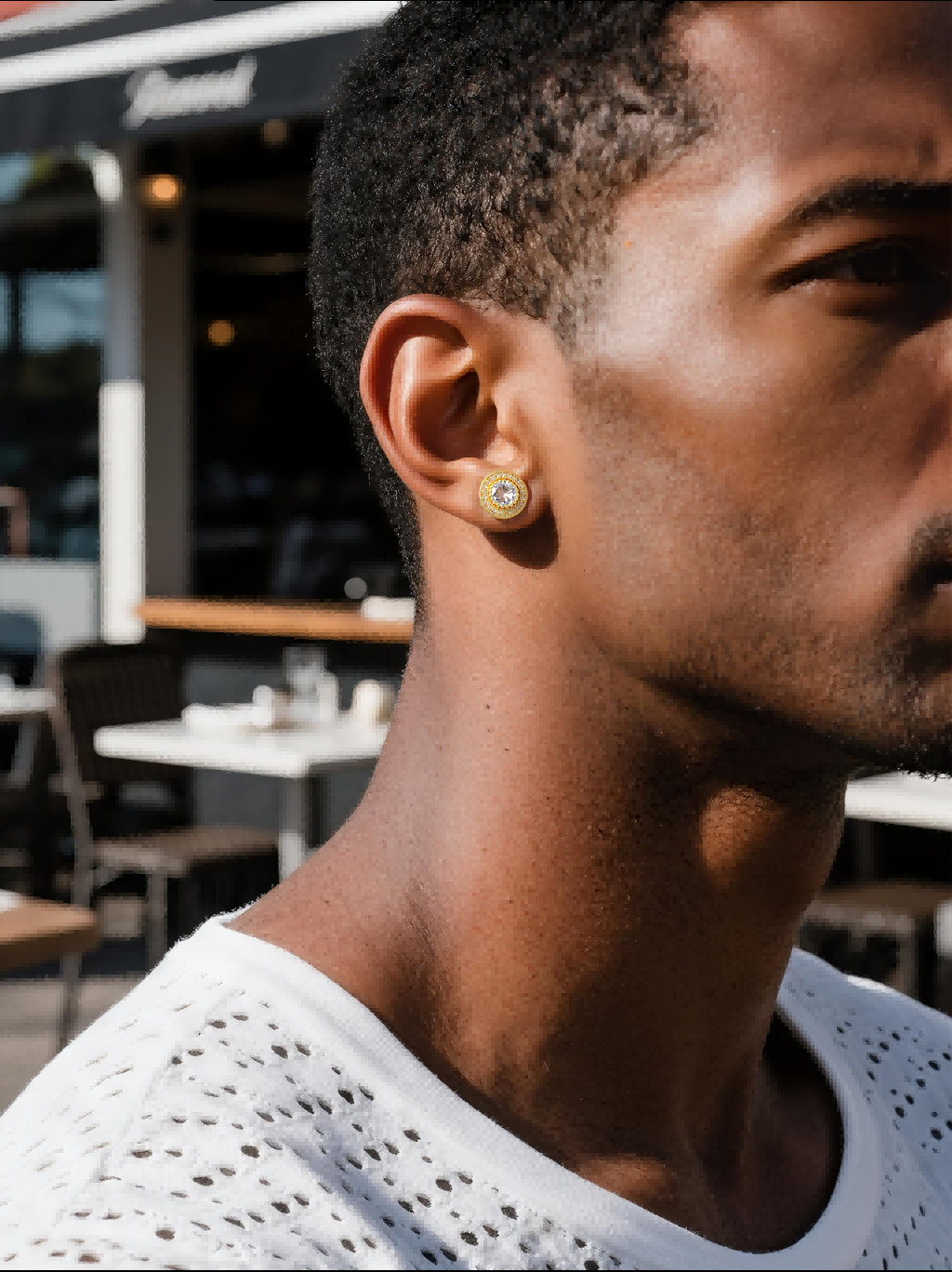 Man wearing Own Your Bloom 14K round full-gold diamond stud earring while painting graffiti, Brooklyn NYC street style, USA.