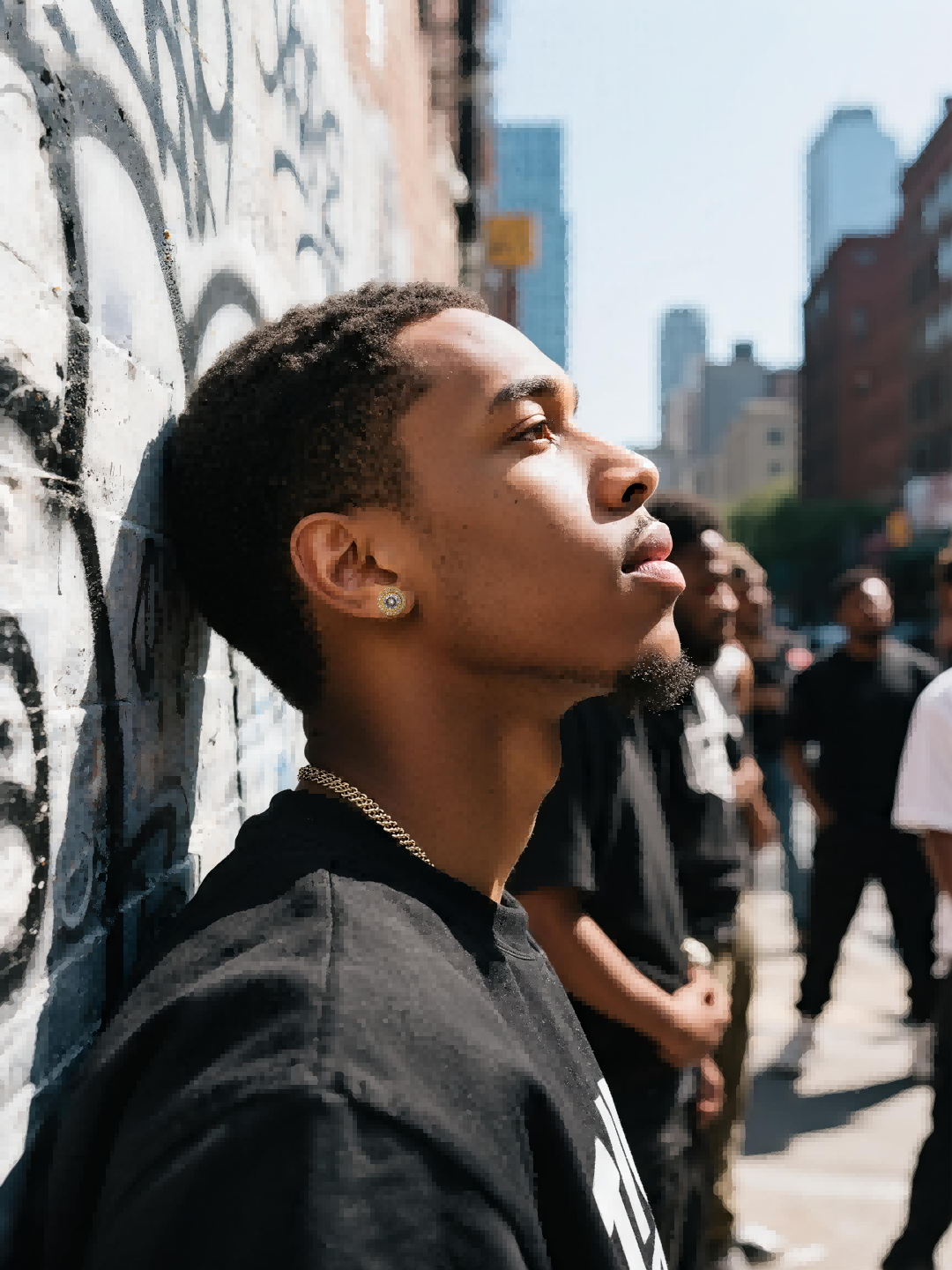 Close-up of a man at a sidewalk café wearing Own Your Bloom 14K round full-gold diamond stud earring, downtown New York vibe, USA.