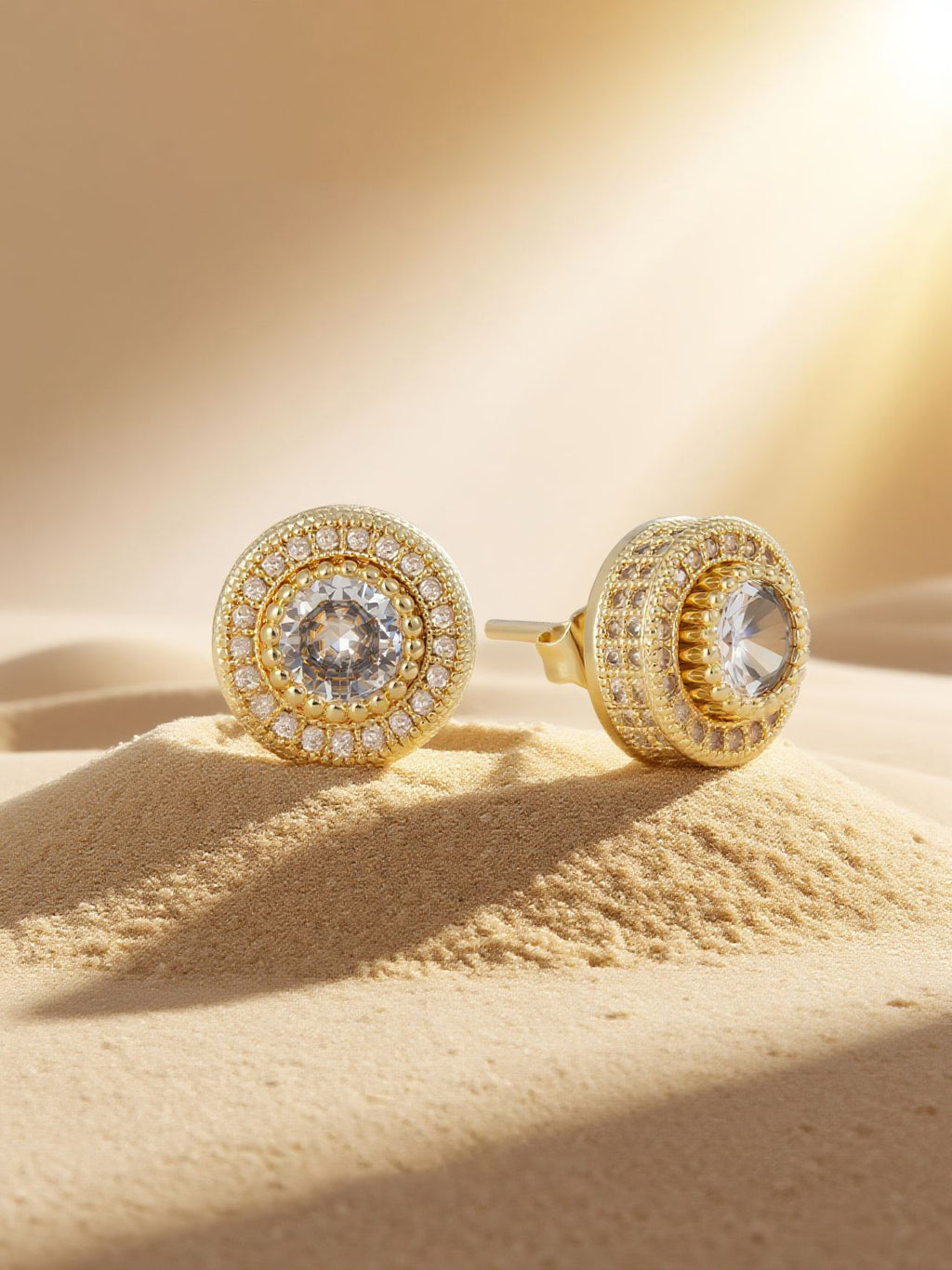 Single Own Your Bloom 14K round full-gold diamond stud on sand with sunbeam, lifestyle scene for US audience.