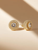 Own Your Bloom round full-gold diamond studs styled on warm sand under golden light, Southwest USA desert vibe.