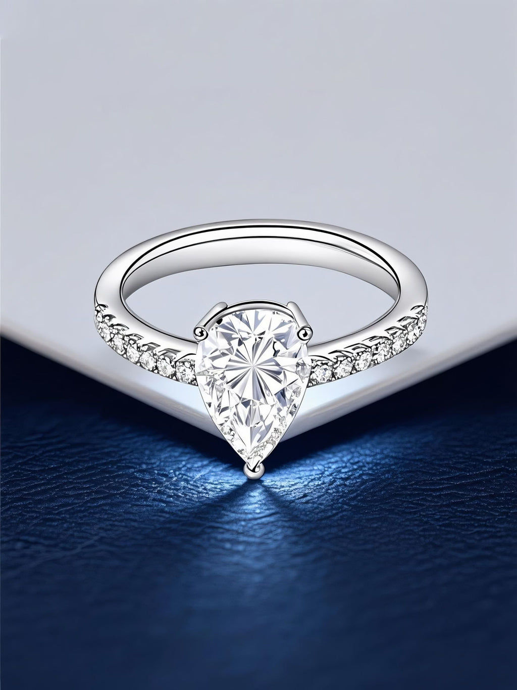 Own Your Bloom 14K teardrop diamond ring displayed on elegant navy surface with light reflection, luxury fine jewelry, Dallas.