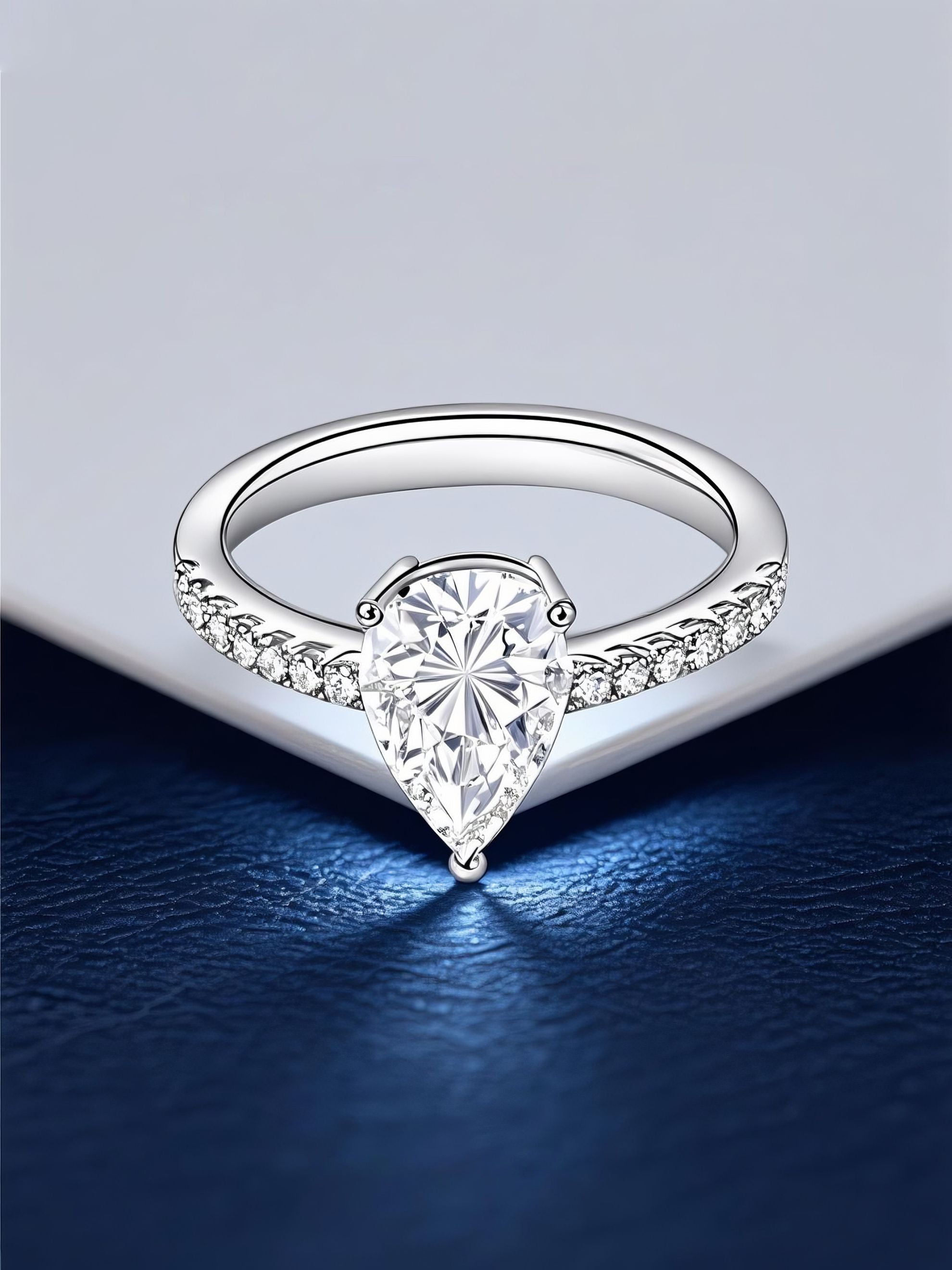 Own Your Bloom 14K teardrop diamond ring displayed on elegant navy surface with light reflection, luxury fine jewelry, Dallas.