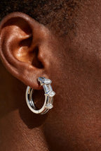 Man ear close-up wearing Own Your Bloom 14K white gold marquise diamond hoop earring in daylight, Atlanta.