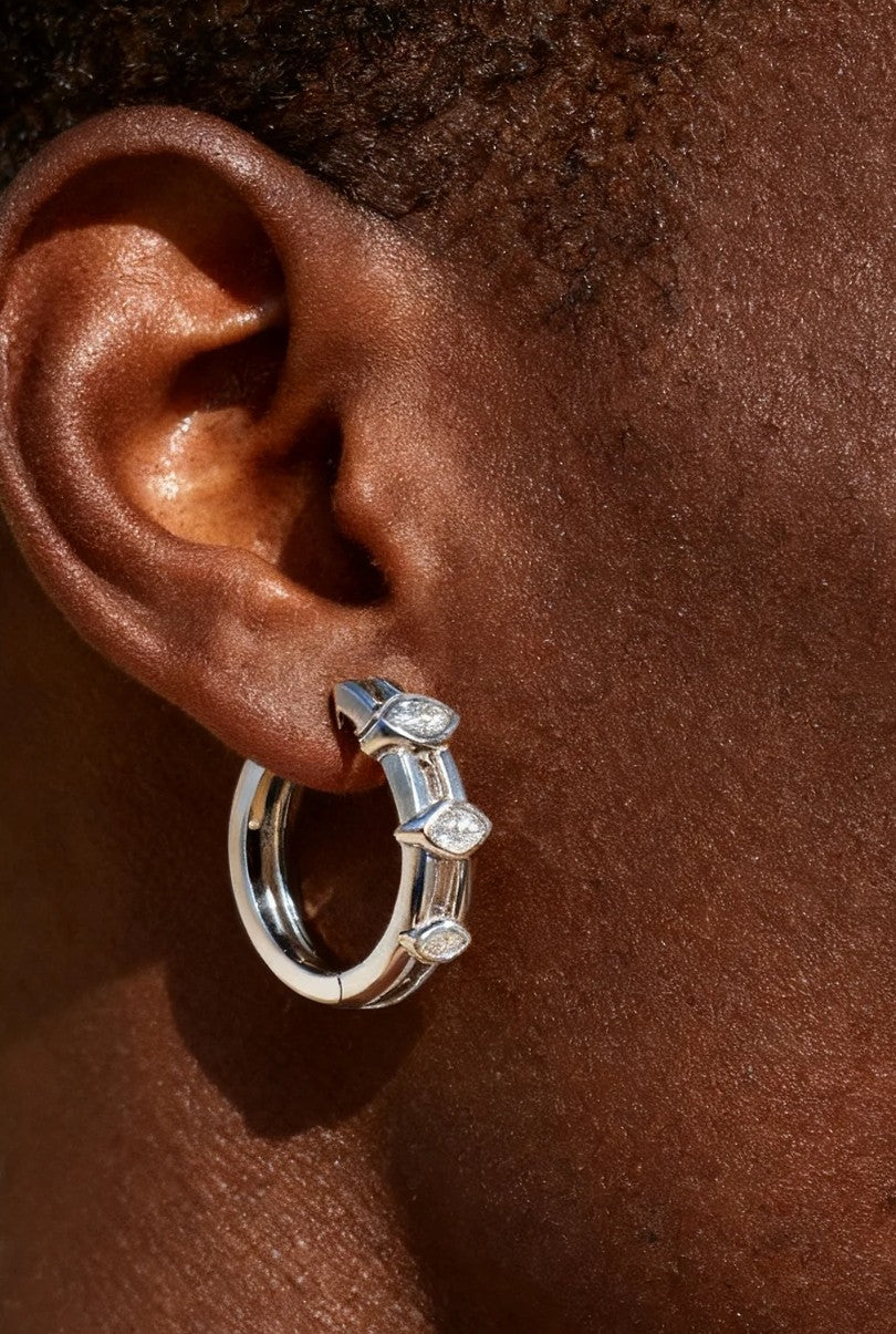 Man ear close-up wearing Own Your Bloom 14K white gold marquise diamond hoop earring in daylight, Atlanta.