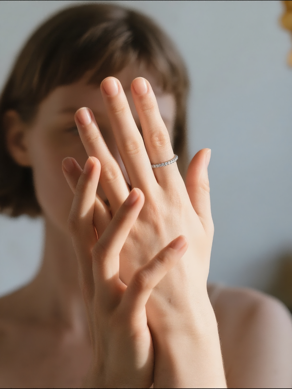 Woman wearing the Own Your Bloom 14K white gold slim pavé diamond band while holding flowers, outdoor daylight, Austin.