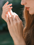 Woman wearing the Own Your Bloom 14K white gold slim pavé diamond band in a natural garden setting, Denver.