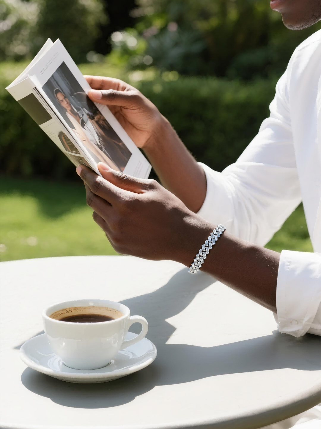 Own Your Bloom 14K diamond Cuban bracelet worn by man reading at café, modern minimalist men’s jewelry, Miami.