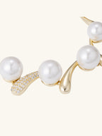 Top view of Own Your Bloom Australian white shell pearl 14K gold diamond bracelet on white background, Miami USA.