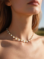 Own Your Bloom Australian white shell pearl 14K gold necklace worn by woman outdoors in soft breeze, Austin.