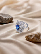 Own Your Bloom Blue Sapphire Diamond Halo Ring showcased in a serene studio setting, reflecting timeless luxury, Boston.
