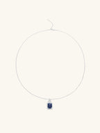 Own Your Bloom radiant blue sapphire halo pendant front view in white gold, showcasing cushion-cut sapphire surrounded by diamond halo, New York.