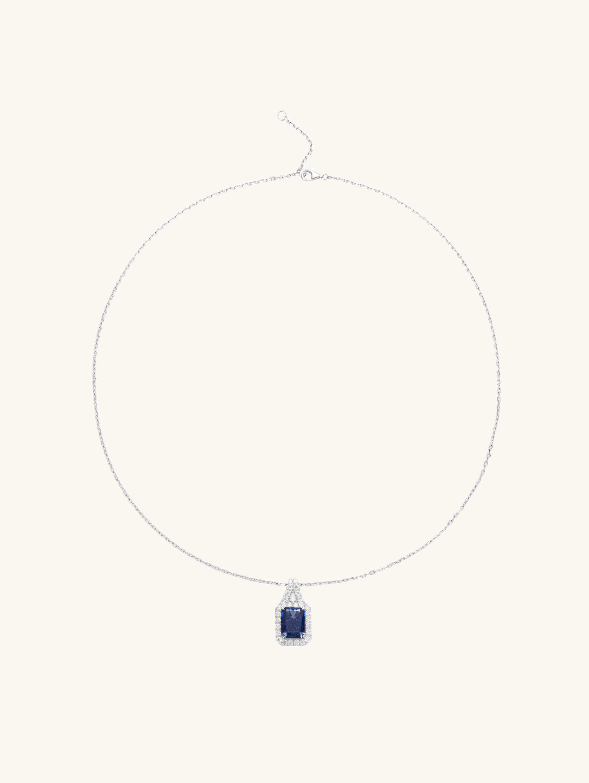 Own Your Bloom radiant blue sapphire halo pendant front view in white gold, showcasing cushion-cut sapphire surrounded by diamond halo, New York.